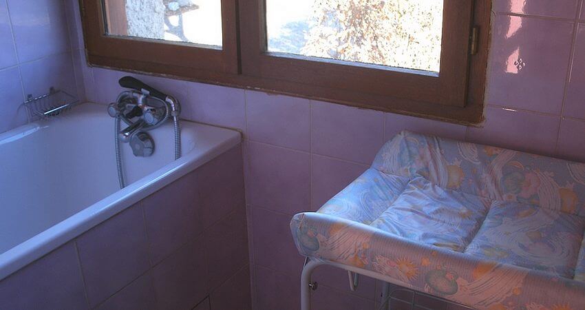 Salle de bains pour bébé avec baignoire et table à langer